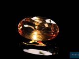a yellow sapphire stone on a black surface