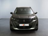 the front of a grey car in a room with a white wall