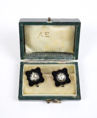une photo d'une paire de boucles d'oreilles noires et blanches dans une boîte