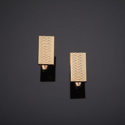 une paire de boucles d'oreilles en or sur fond noir