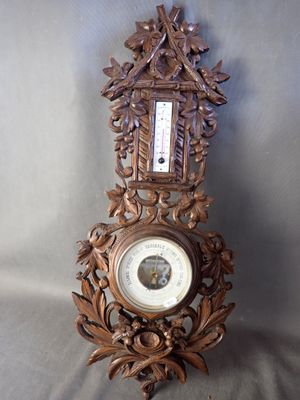 une horloge posée sur une table sur laquelle se trouve un baromètre