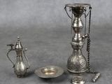 une image représentant un ensemble d'objets argentés sur fond gris