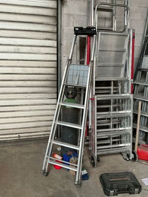 de nombreuses échelles empilées dans un garage