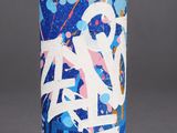 a blue spray can with graffiti on it sitting on a gray surface