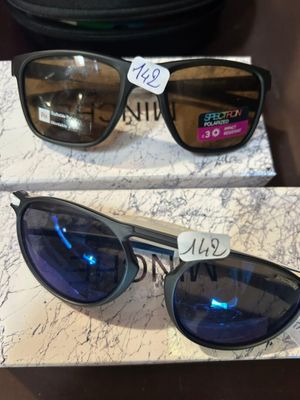 deux paires de lunettes de soleil sont posées sur une boîte sur laquelle est apposée une étiquette de prix