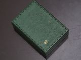 green leather box with a gold crown on the top of it