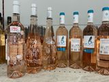 Plusieurs bouteilles de vin rosé sont alignées sur un comptoir
