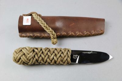 a knife with a rope wrapped around it on a table