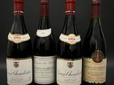 quatre bouteilles de vin sont alignées sur une surface noire