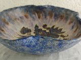 a blue and brown bowl sitting on a white table