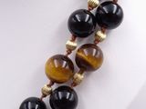 tiger eye bead necklace on a mannequin necklace with gold and black beads