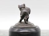 a statue of a dog holding a cat on top of a table