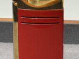 un briquet rouge posé sur une table près d'un mur blanc