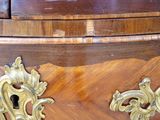 a wooden dresser with a brass handle on top of it
