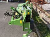 the machine is sitting on the side of the road by the fence