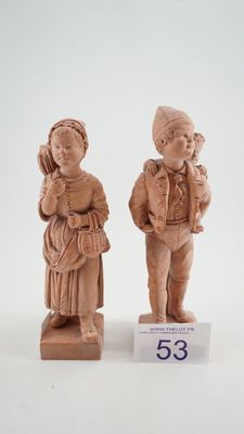 paire de figurines sculptées représentant un garçon et une fille tenant un bébé dans leurs bras