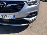 a close up of a silver car parked in a parking lot