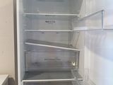 an empty refrigerator with the door open in a kitchen