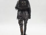 statue of a man with a backpack on his back standing on a rock