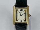 an image of a gold and black watch with roman numerals