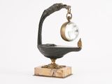 une horloge posée sur un socle sur lequel est perché un oiseau