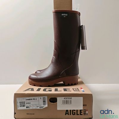 une photo d'une paire de bottes de pluie marron posées sur une boîte