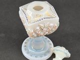 a small glass candle holder with a small candle on top of it