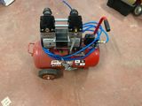 a small air compressor sitting on the floor in the garage