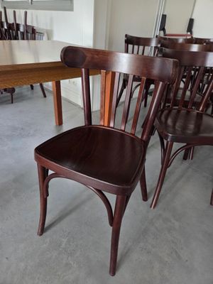 de nombreuses chaises en bois et une table dans une pièce
