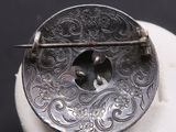 une broche en argent avec un oiseau au centre