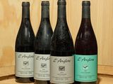 plusieurs bouteilles de vin sont alignées sur une étagère en bois