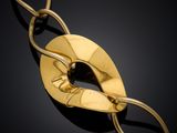 a close up of a gold necklace on a black surface