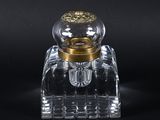 flacon de parfum en verre transparent avec un bouchon doré, sur fond noir
