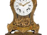 une horloge dorée accrochée au mur, avec des chiffres romains