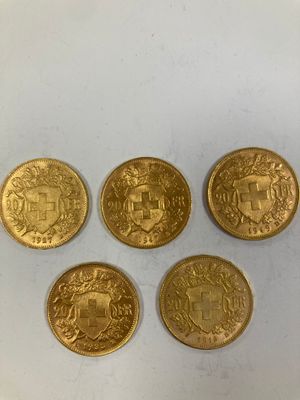 quatre types différents de pièces d'or reposant sur une surface blanche
