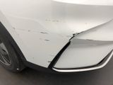 the front end of a white car with a damaged bumper