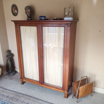 une armoire en bois dans un coin d'une pièce où se trouve un tapis bleu