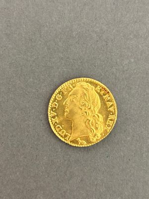 a close up of a gold coin on a gray surface