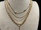 a gold chain necklace with a star charm on top of it