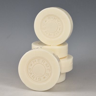 trois pains de savon blancs empilés les uns sur les autres sur une surface grise