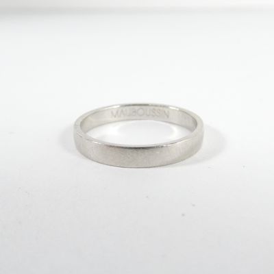 gros plan d'une bague en argent sur une surface blanche