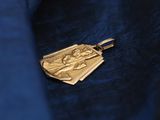 a close up of a gold medal on a blue jacket