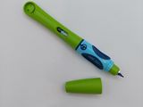 a green pen and a green marker on a white surface