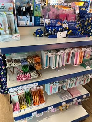 many pens and pencils on the shelves in the store