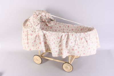 a small doll ' s pram with a floral cover on it