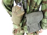 soldier in camouflage holding a bag and a cell phone in his hand