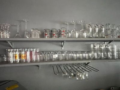 de nombreux verres et cuillères sur les étagères de la cuisine