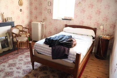 un lit dans une chambre avec une cheminée et un fauteuil