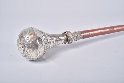 an old silver pipe with a wooden handle on a white surface