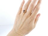 a woman ' s hand with a ring on it
